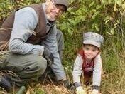 This is a photo of a dad and his young son planting trees.