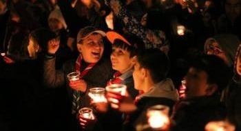 This is a picture of Girl and Boy Scouts laughing and holding candles in celebration of Earth Hour.