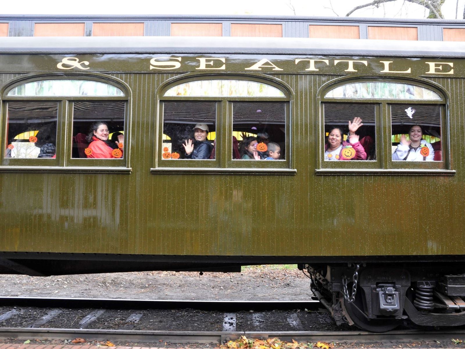This is a picture of an antique train car with children waving.