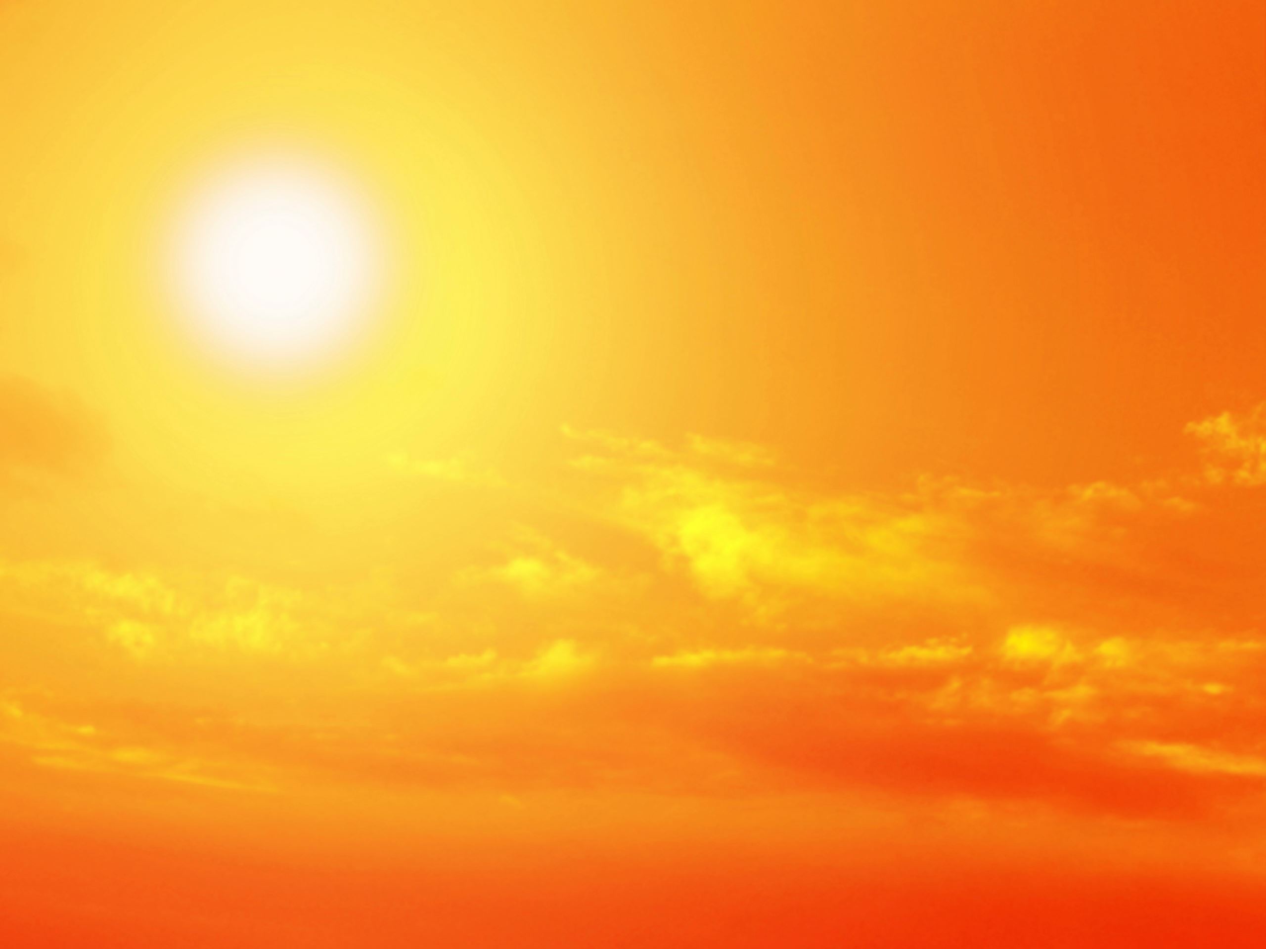 This is a picture of a very right sun in an orange sky to indicate a very hot day.